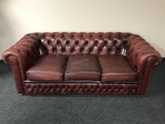 A red button leather Chesterfield three seater settee