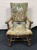 An early 20th century oak armchair in tapestry fabric