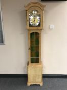 A blond oak Tempus Fugit longcase clock with pendulum and weights