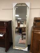 A silvered bevelled rectangular mirror in silvered frame