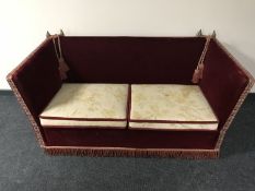 A 20th century drop end settee upholstered in red