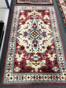 A woollen Eastern style rug on red ground