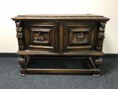 An early 20th century carved oak double door low sideboard
