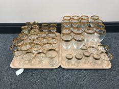 Two trays containing assorted gilt-rimmed glassware