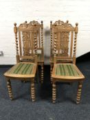 A set of four carved oak dining chairs on turned legs