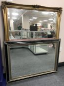 A large gilt framed bevelled overmantel mirror together with a silver and black framed mirror
