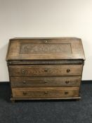 A 19th century carved oak bureau fitted three drawers