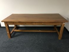 A contemporary refectory kitchen table fitted three drawers