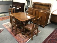 An early twentieth century carved oak dining room suite comprising of pull out table,
