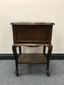 An early 20th century oak sewing trolley