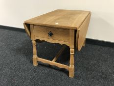 A blond oak drop leaf coffee table fitted a drawer