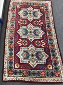 A woollen Eastern style rug on red ground