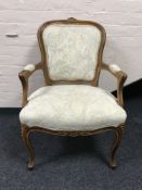 A carved walnut framed armchair in floral fabric