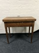 An early 20th century mahogany turnover top tea table