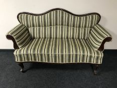 A mahogany framed scroll armed settee in striped fabric