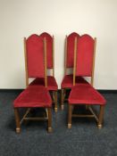 A set of four blond oak high-backed dining chairs upholstered in a red fabric