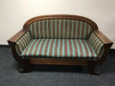 An early 20th century mahogany framed settee upholstered in a green striped fabric