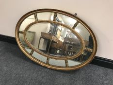 An early 20th century gilt framed oval sectional mirror