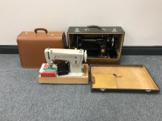 Two cased Singer electric sewing machines