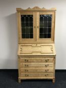 A blond oak bureau bookcase with leaded glass doors