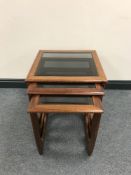 A nest of three late 20th century Sunelm teak glass topped tables