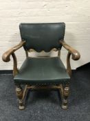 A 20th century carved oak armchair upholstered in green buttoned leatherette