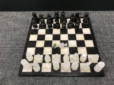 A marble chess board with onyx pieces