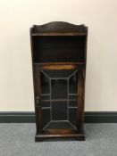 An oak leaded door cabinet fitted a shelf above