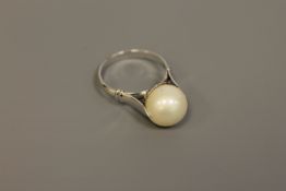 A large pearl ring, the 11mm pearl set in white metal with foreign marks to outside of shank,
