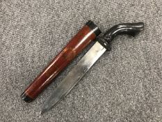 A curved handed knife in a lacquered sheath