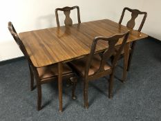 A mid 20th century teak dining table with leaf and four mahogany chairs