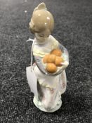 A Lladro figure - girl with basket of oranges