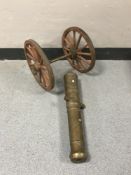A heavy brass cannon with wooden wheels,