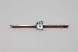 A gold and platinum bar brooch set with an aquamarine
