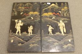 A pair of Japanese Meiji period lacquered and inlaid panels depicting figures in a mountainous