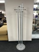 A contemporary metal hat and coat stand on circular base
