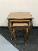 A nest of three inlaid mahogany French tables with gilt metal mounts