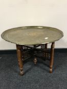 A folding brass-topped table