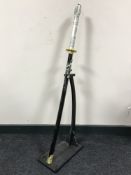 A Dragon handled samurai style sword on stand with scabbard CONDITION REPORT: