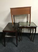 A nest of two mahogany leather topped tables together with two tier side table and storage sewing