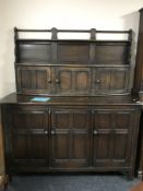 An Ercol triple door sideboard fitted with cupboards and plate rack above