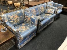 A three piece lounge suite upholstered in blue floral print depicting birds