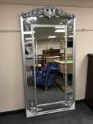 A large bevelled silvered mirror in ornate frame