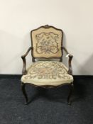 A carved walnut armchair upholstered in floral tapestry fabric