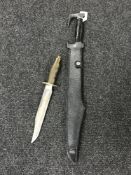 A machete in leather sheath together with a hunting knife