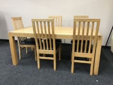 A contemporary oak dining table together with a set of five rail back chairs