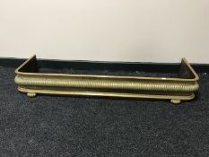 An early twentieth century brass fire curb