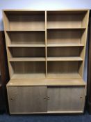 A late 20th century set of teak shelves fitted with cupboards below