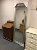 A silvered bevelled rectangular mirror in silvered frame