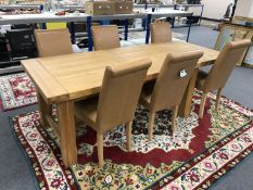 A contemporary pine dining table with extending leaves and a set of six tan leather high-backed